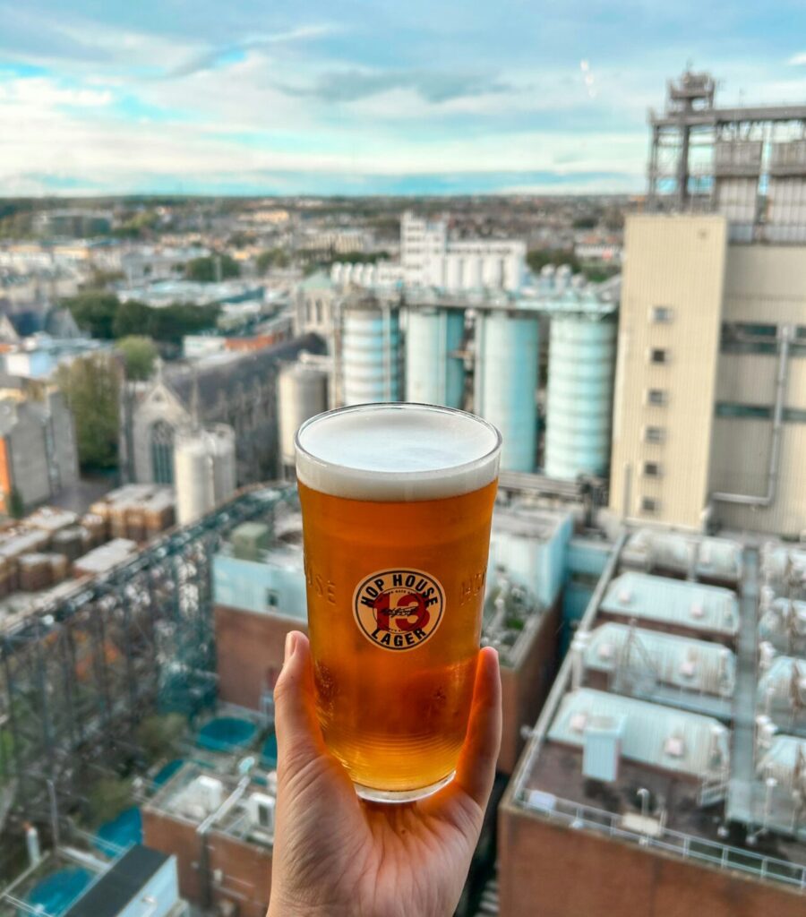 A person holding a glass of beer in front of the cityscape at the Gravity Bar. Photo by Sophie Popplewell. A person holding a glass of beer in front of the cityscape at the Gravity Bar. Photo by Sophie Popplewell.